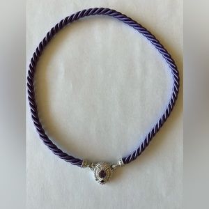 Judith Ripka purple silk chord necklace with silver and purple ornament.